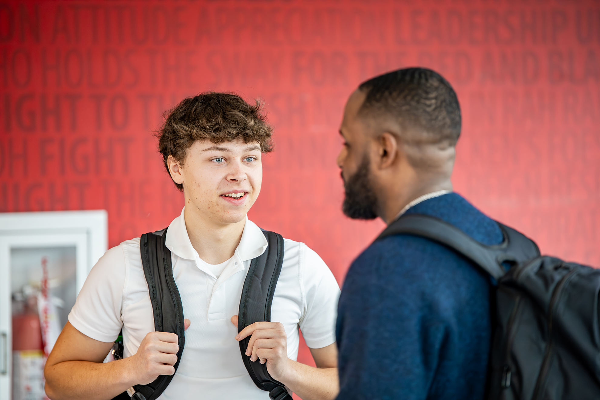 Two CECH students share a conversation in a campus lobby